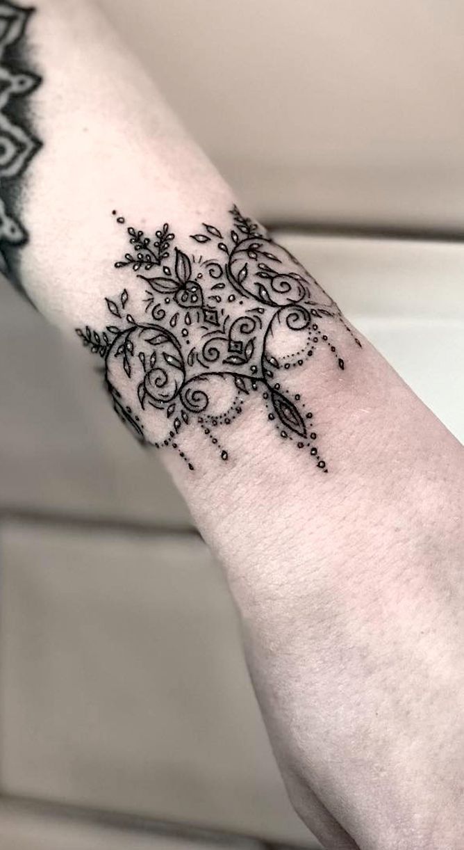 Hình xăm hoa văn cổ điển đen trên cổ tay, chi tiết tinh xảo, phong cách blackwork, độ phân giải HD.