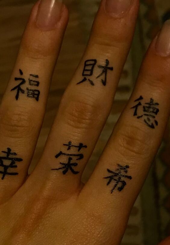 Hình xăm chữ Hán trên ngón tay, phong cách blackwork, chi tiết rõ nét, độ phân giải HD.