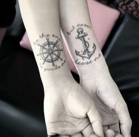 Hình xăm bánh lái và mỏ neo trên cổ tay, phong cách blackwork, chi tiết rõ nét.