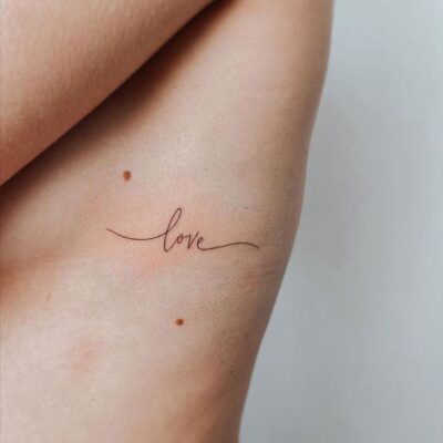 Chữ "love" hình xăm mini trên xương sườn, phong cách tối giản, ảnh độ phân giải HD.