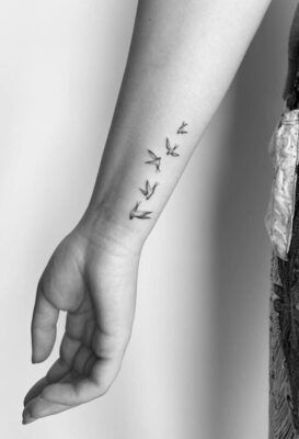 Hình xăm chim mini trên cẳng tay, phong cách blackwork, ảnh đen trắng, độ phân giải HD.