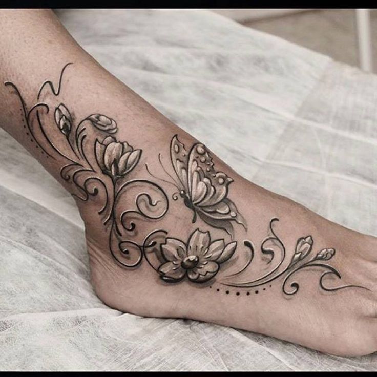 Hình xăm hoa và bướm trên chân, phong cách blackwork, chi tiết tinh tế, ảnh chất lượng HD.