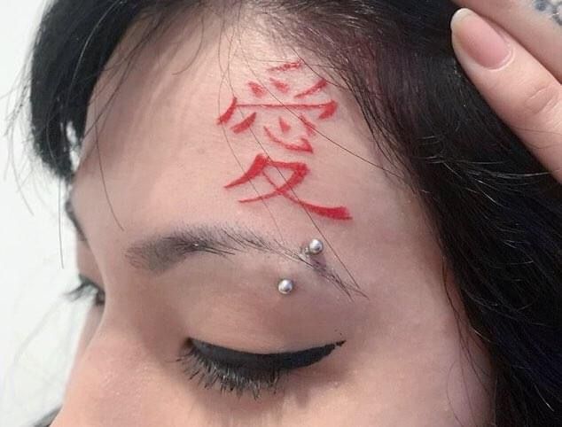 Hình xăm chữ Hán đỏ trên trán, phong cách cổ điển, chi tiết rõ nét, ảnh HD.
