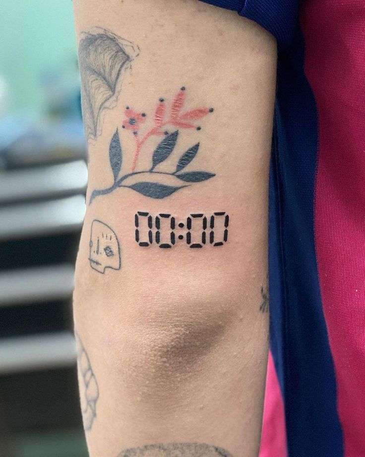 bắt mắt với mẫu tattoo chữ số trên bắp tay Hình xăm mini trên tay với số 00:00, phong cách tối giản, độ chi tiết cao, ảnh HD.