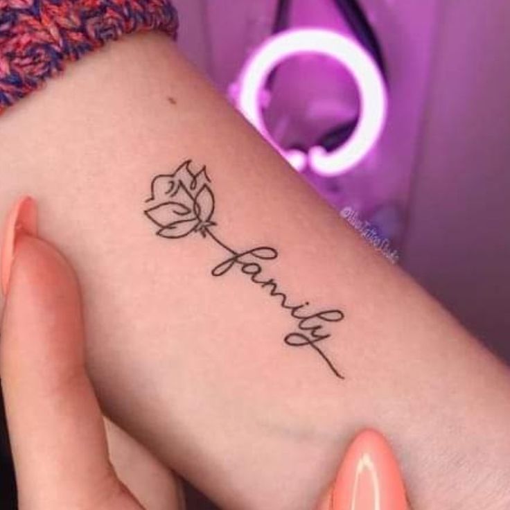 Hoa hồng kết hợp với chữ 'gia đình' mini Hình xăm mini chữ "family" và hoa hồng trên tay, phong cách blackwork, ảnh HD.
