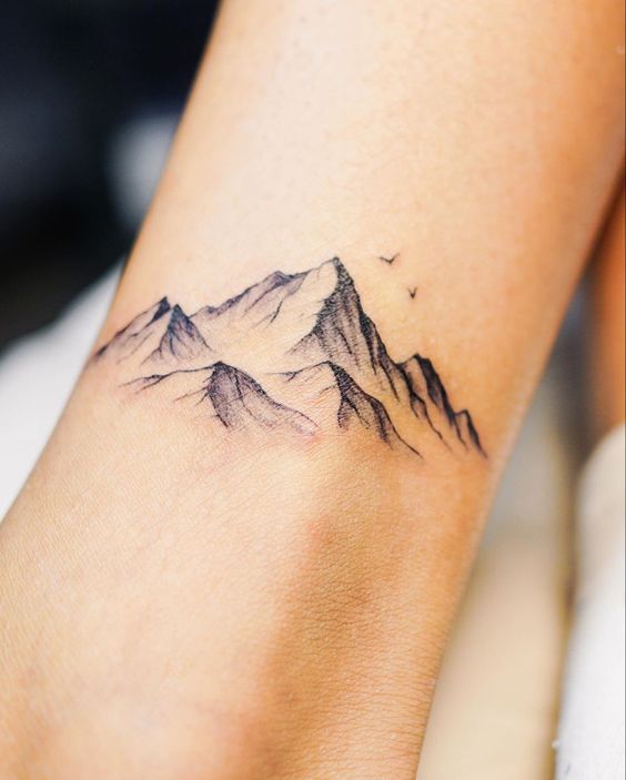 Hình xăm phong cảnh núi trên tay, phong cách blackwork chi tiết, ảnh độ phân giải cao.