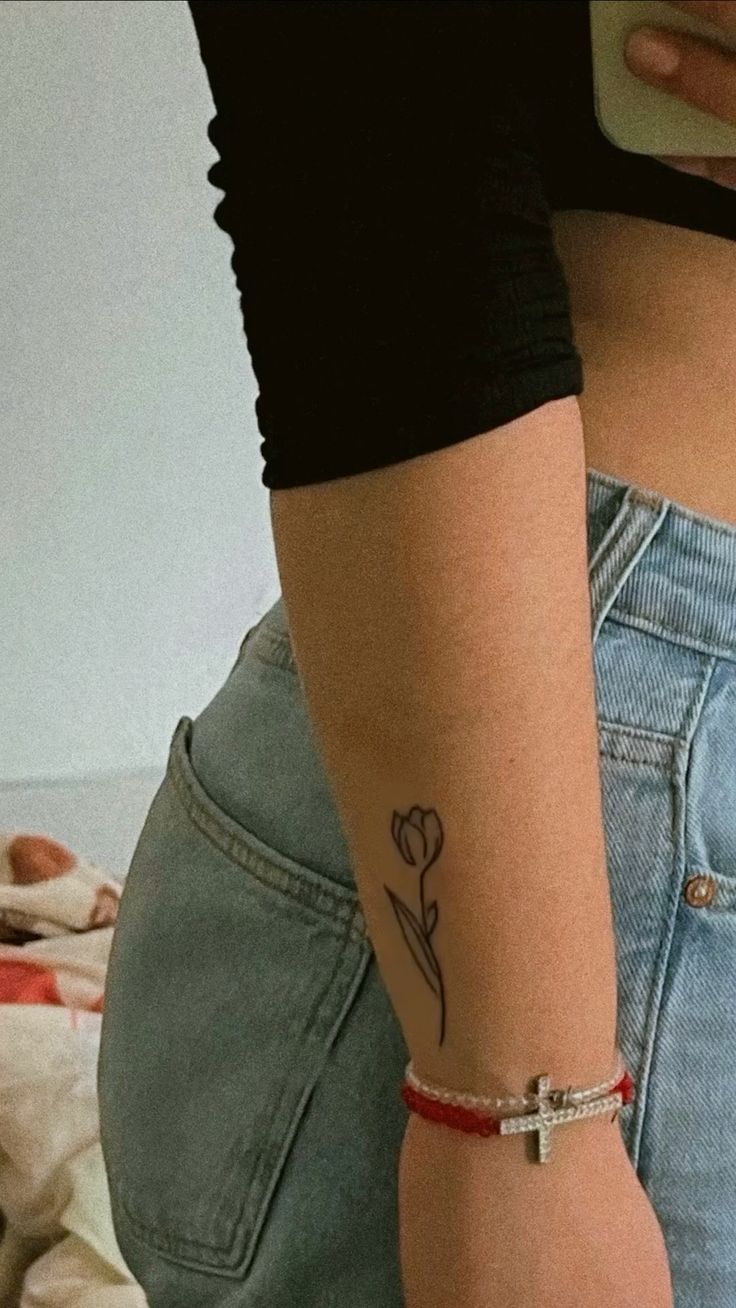Hình xăm hoa tulip mini ở cánh tay, phong cách blackwork, chi tiết rõ nét, độ phân giải ảnh HD.