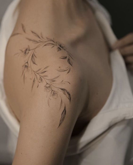Hình xăm hoa lá trên vai, phong cách blackwork, chi tiết tinh tế, ảnh chất lượng HD.
