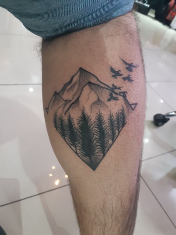 Hình xăm phong cảnh núi và rừng trên bắp chân, phong cách blackwork, chi tiết rõ nét, độ phân giải HD.