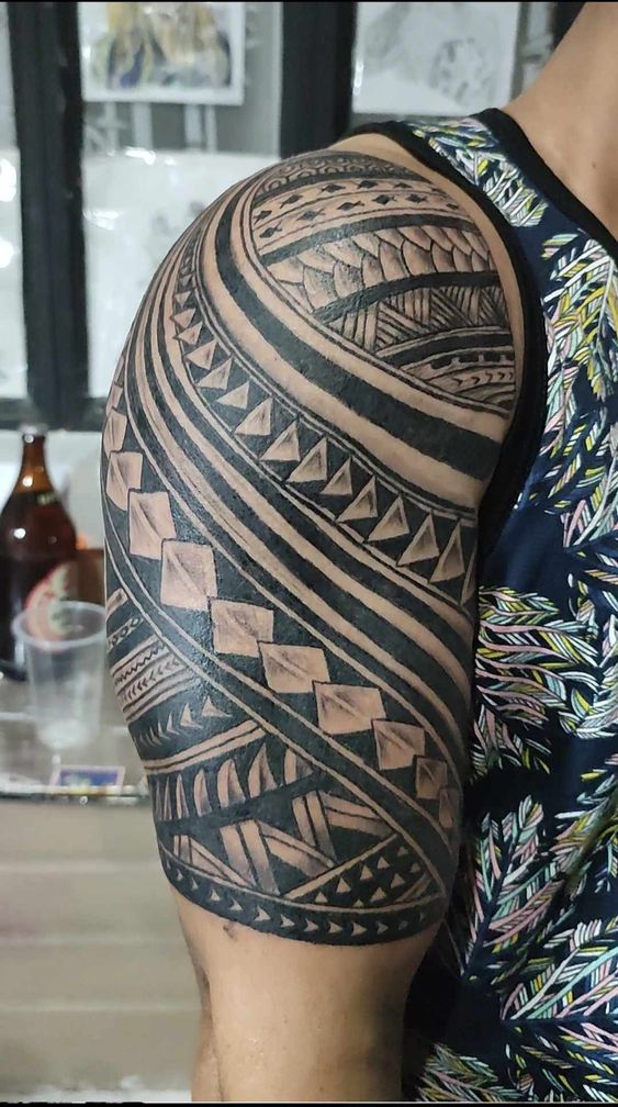 Hình xăm tribal trên bắp tay, phong cách blackwork, chi tiết sắc nét, độ phân giải HD.