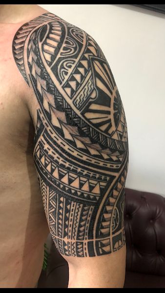 Hình xăm họa tiết bộ lạc trên bắp tay, phong cách blackwork, chi tiết sắc nét, độ phân giải HD.