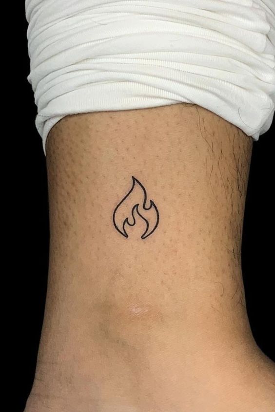 đơn giản với hình xăm lửa mini đáng yêu Hình xăm ngọn lửa mini ở cổ chân, phong cách blackwork tối giản, ảnh HD sắc nét.