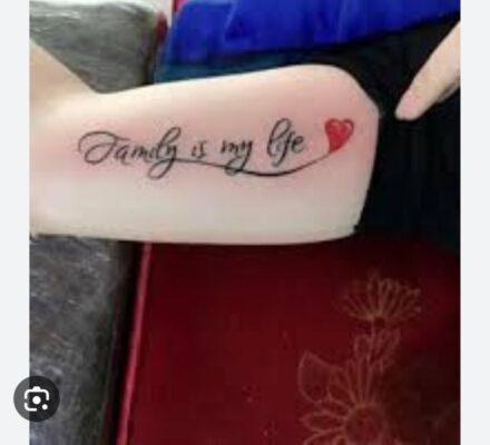 Hình xăm chữ "Family is my life" với trái tim đỏ ở bắp tay, phong cách chữ viết tay, ảnh chất lượng HD.