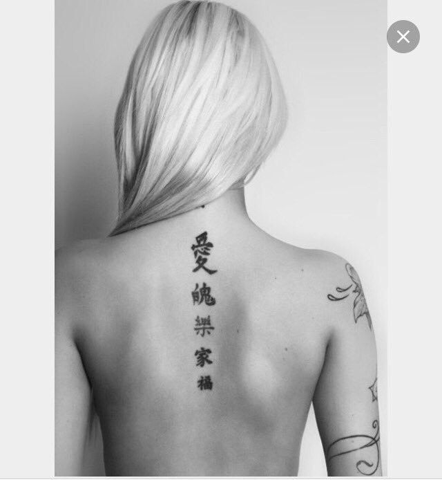 Hình xăm chữ Hán dọc lưng, phong cách blackwork, ảnh đen trắng rõ nét.