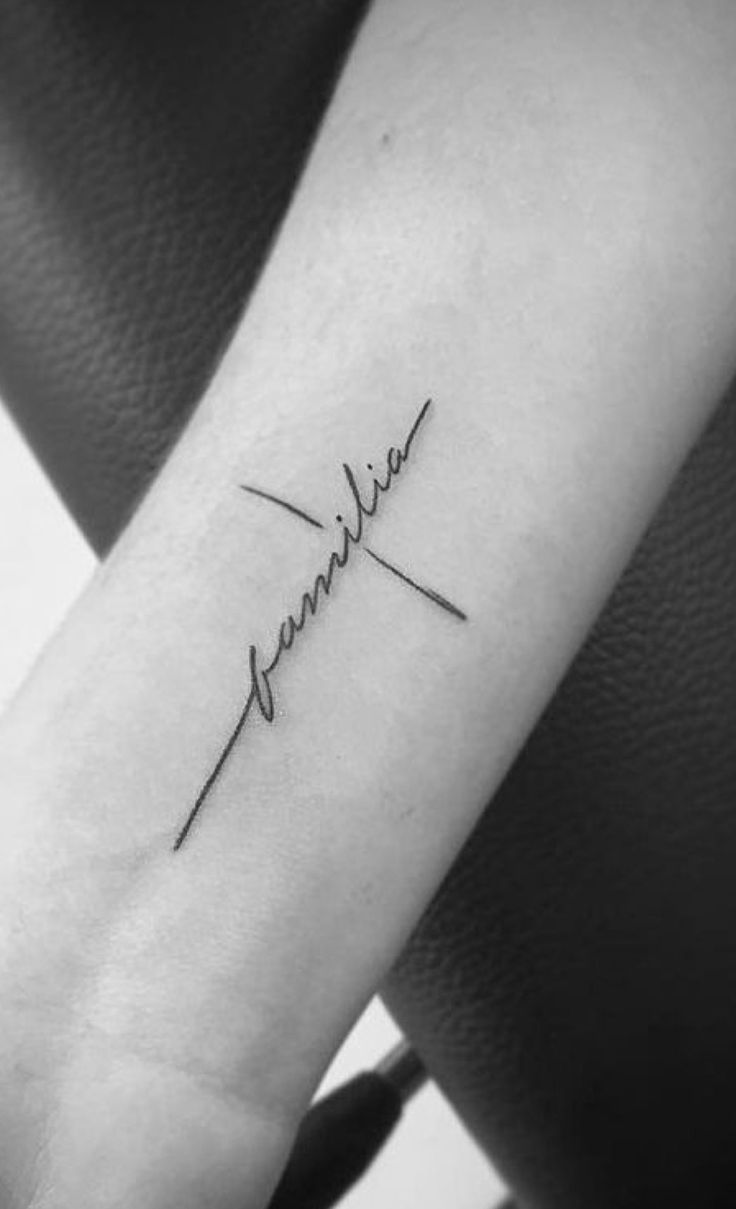 Luôn giữ gìn hai chữ 'gia đình' bên mình Hình xăm chữ "familia" phong cách blackwork trên cánh tay, chi tiết tối giản, độ phân giải HD.