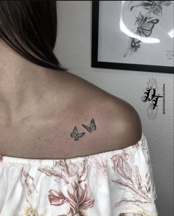 Hình xăm bướm mini trên vai, phong cách blackwork, chi tiết tinh tế, độ phân giải HD.