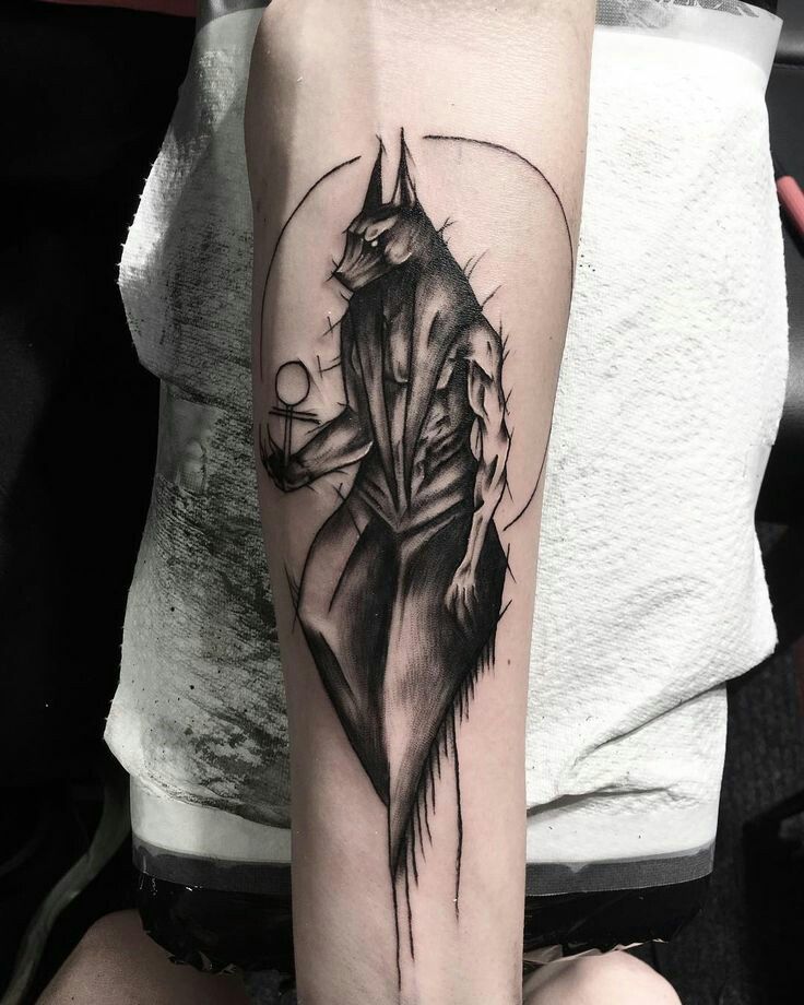Hình xăm nhân vật huyền bí trên cánh tay, phong cách blackwork chi tiết, độ phân giải HD.