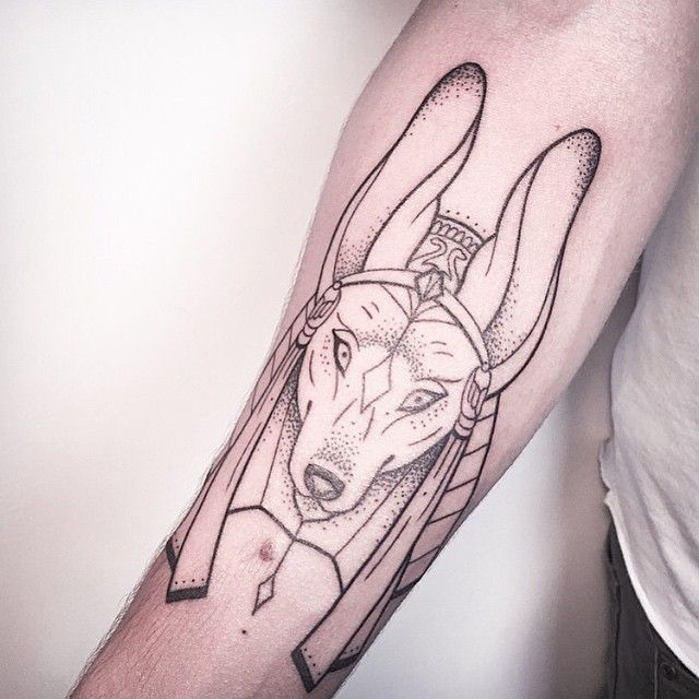 Hình xăm Anubis phong cách blackwork trên cánh tay, chi tiết rõ nét, độ phân giải cao.