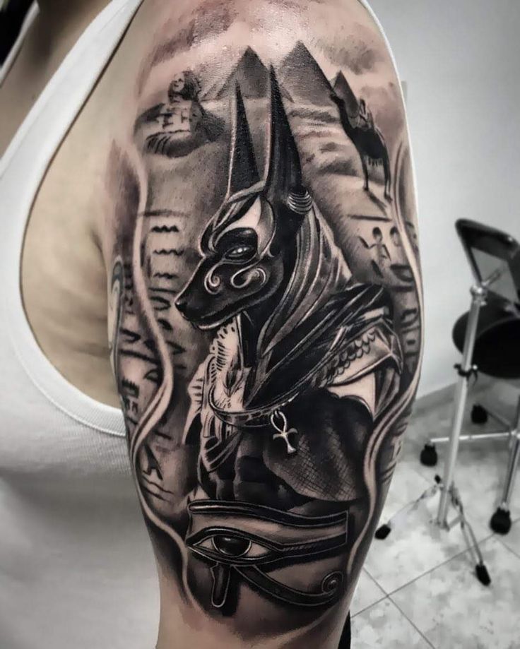 Hình xăm Anubis trên bắp tay, phong cách blackwork, chi tiết cao, độ phân giải HD.