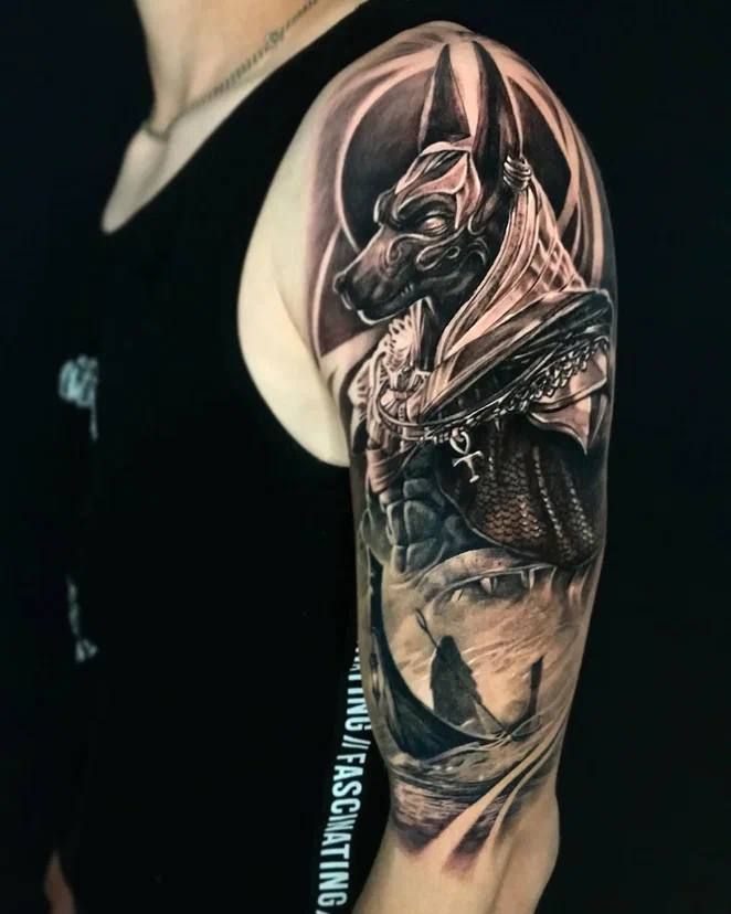 Hình xăm Anubis trên bắp tay, phong cách blackwork chi tiết, ảnh HD.