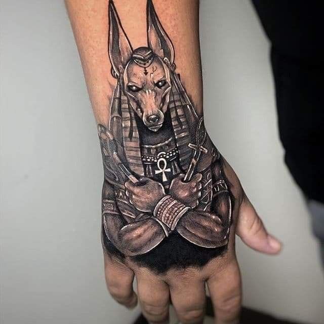 Hình xăm thần chó Anubis trên mu bàn tay, phong cách blackwork chi tiết, độ phân giải HD.