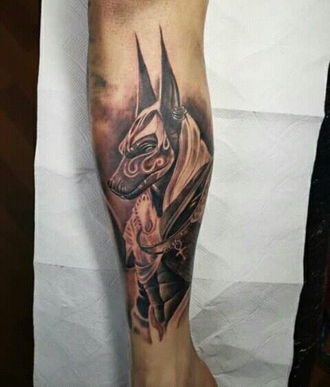 Hình xăm Anubis ở cẳng chân, phong cách blackwork chi tiết, độ phân giải HD.