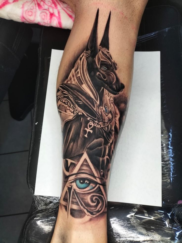 Hình xăm Anubis chi tiết trên bắp tay, phong cách blackwork, độ phân giải cao.