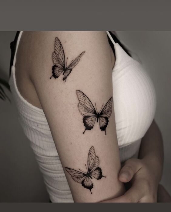 Hình xăm bướm blackwork trên cánh tay, phong cách tinh tế, độ phân giải HD.