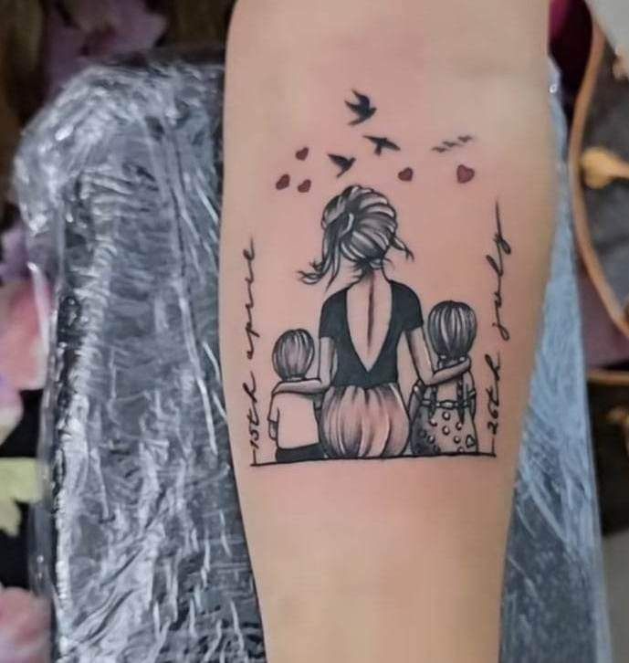 hình xăm ba mẹ con ngồi nhìn lên bầu trời Hình xăm gia đình trên cánh tay, phong cách blackwork, chi tiết tinh tế, độ phân giải HD.