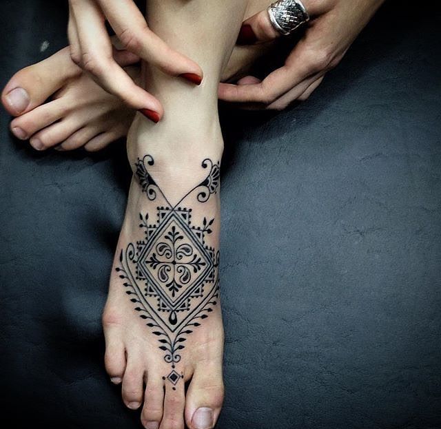 Hình xăm họa tiết blackwork trên mu bàn chân, chi tiết tinh xảo, phong cách cổ điển, độ phân giải cao.