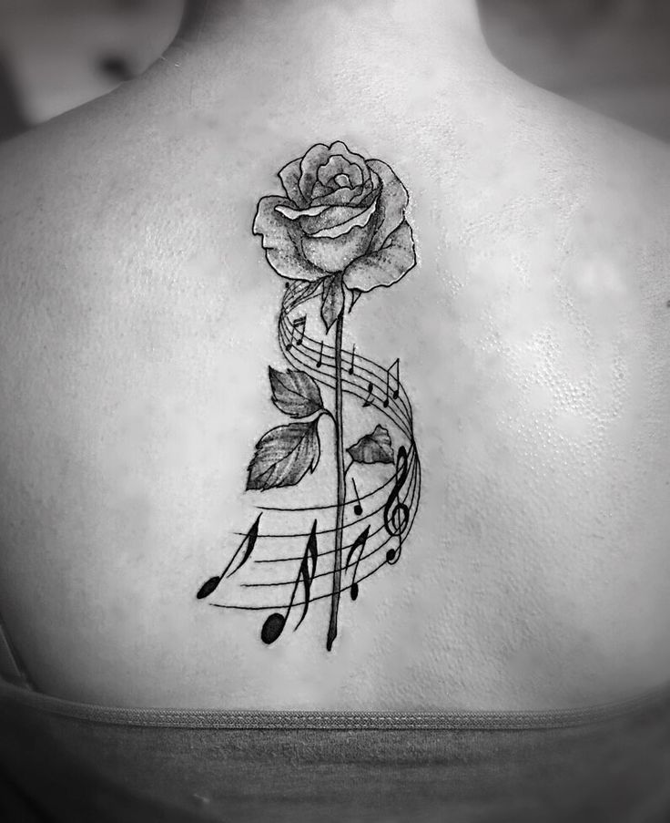 Hình xăm hoa hồng và nốt nhạc trên lưng, phong cách blackwork, chi tiết rõ nét, độ phân giải HD.