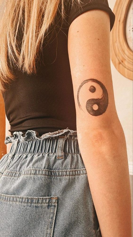 Hình xăm yin yang trên cánh tay, phong cách blackwork, chi tiết sắc nét, ảnh HD.