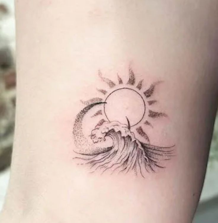 Hình xăm sóng biển và mặt trời, phong cách blackwork, vị trí cổ tay, chi tiết tinh xảo, ảnh chất lượng HD.