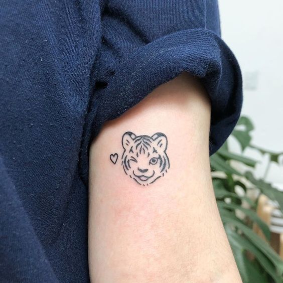 Hình xăm mini đầu hổ phong cách blackwork trên cánh tay, chi tiết rõ nét, độ phân giải HD.