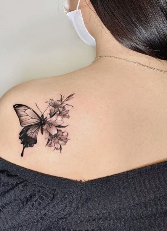 Hình xăm bướm và hoa trên vai, phong cách blackwork, chi tiết rõ nét, độ phân giải HD.