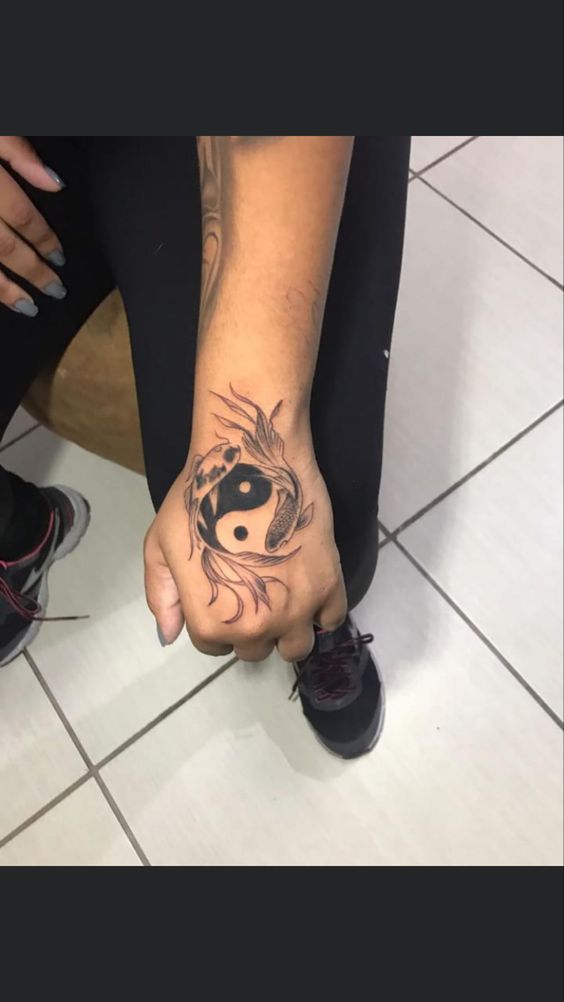 Hình xăm biểu tượng âm dương ở mu bàn tay, phong cách blackwork, ảnh HD chi tiết.