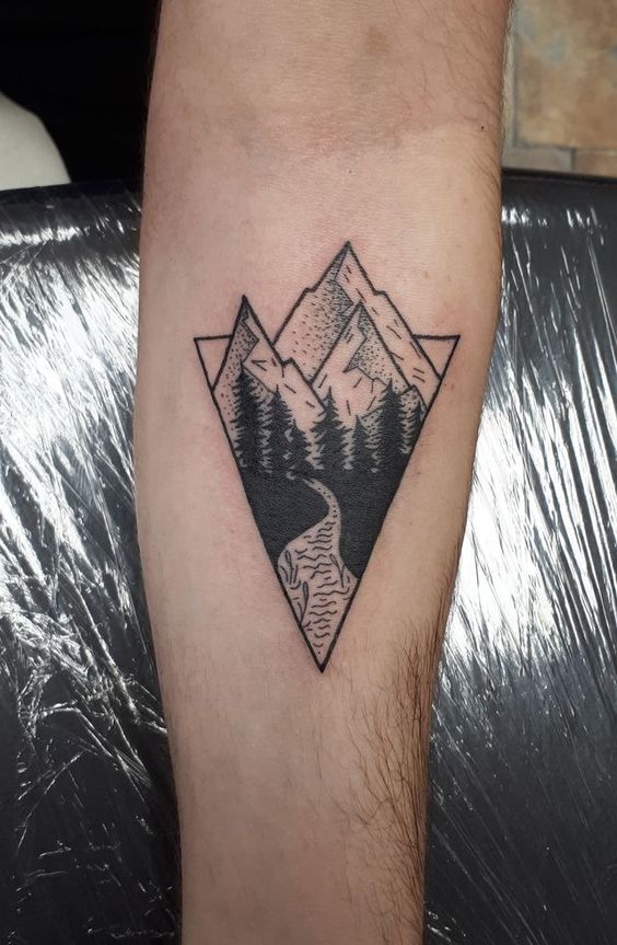 Hình xăm phong cảnh núi rừng trên cánh tay, phong cách blackwork, chi tiết rõ nét, ảnh độ phân giải cao.
