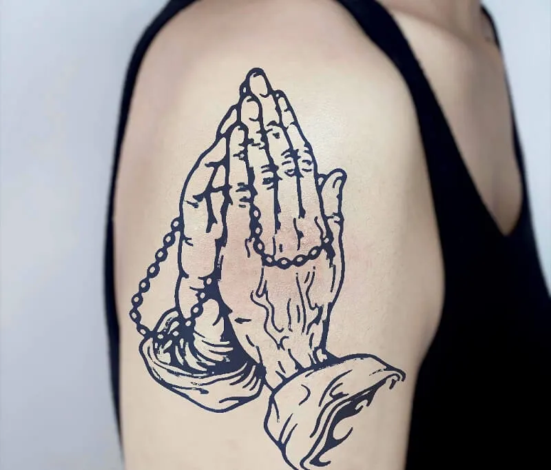 Hình xăm đôi tay cầu nguyện trên vai, phong cách blackwork, chi tiết rõ nét, độ phân giải HD.