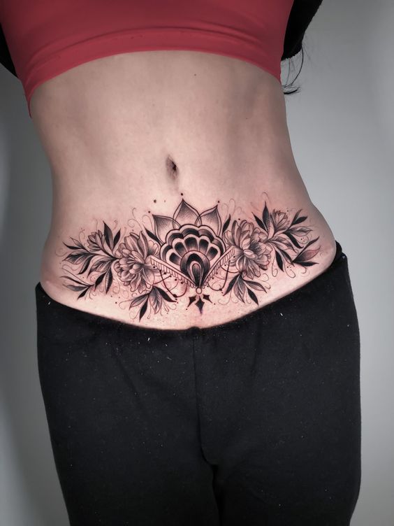 Hình xăm hoa ở bụng, phong cách blackwork, chi tiết tinh xảo, ảnh chất lượng cao.