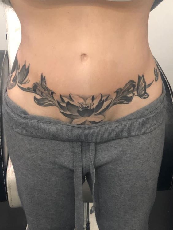 Hình xăm hoa sen blackwork trên bụng, chi tiết rõ nét, ảnh HD.
