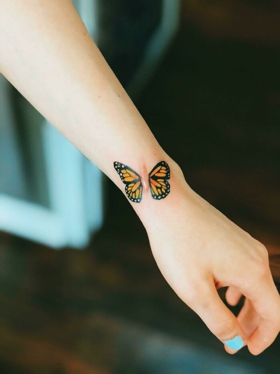 Hình xăm bướm trên cổ tay, phong cách màu sắc, chi tiết rõ nét, độ phân giải HD.