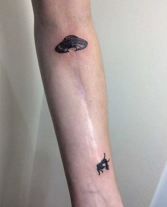 Hình xăm UFO và người bị bắt cóc trên cánh tay, phong cách blackwork, chi tiết, độ phân giải HD.