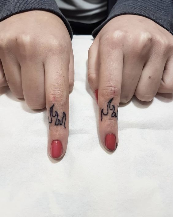 Chi tiết hình xăm lửa cháy trên hai ngón tay Hình xăm ngọn lửa mini trên ngón tay, phong cách blackwork, ảnh độ phân giải HD.