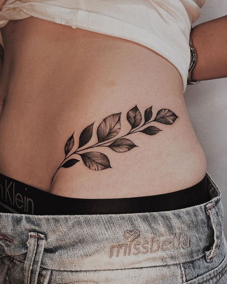 hình xăm chiếc lá ở eo Hình xăm lá cây blackwork trên eo, chi tiết rõ nét, phong cách tối giản, ảnh độ phân giải HD.