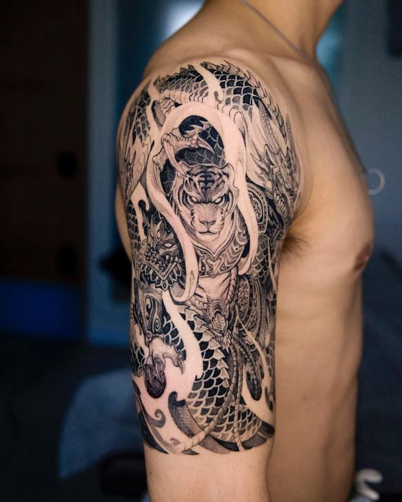 hình xăm chiến binh hổ và rồng kín bắp tay Hình xăm rồng và hổ trên bắp tay, phong cách blackwork chi tiết, ảnh HD.