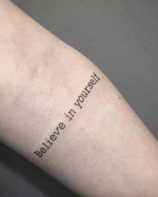 Tattoo nhỏ 'believe in yourself' ở cẳng tay Hình xăm chữ trên cánh tay, phong cách tối giản, độ phân giải HD.