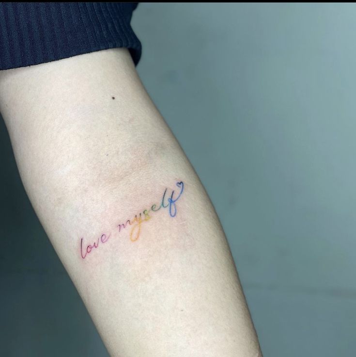 Hình xăm chữ "love myself" màu cầu vồng trên tay, phong cách tối giản, độ phân giải HD.