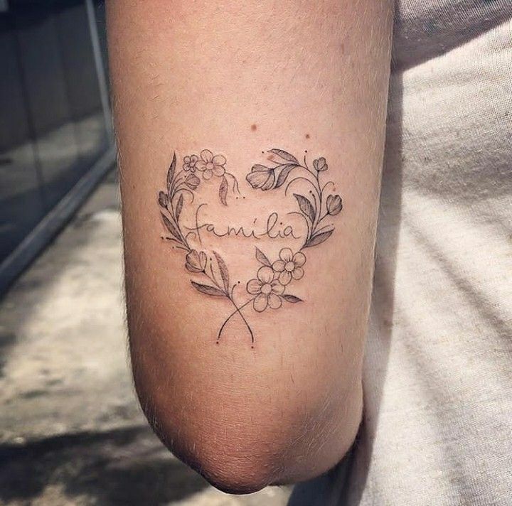 Hình xăm chữ gia đình nhỏ đầy ấn tượng Hình xăm hoa và chữ "familia" trên tay, phong cách blackwork, chi tiết tinh tế, ảnh HD.