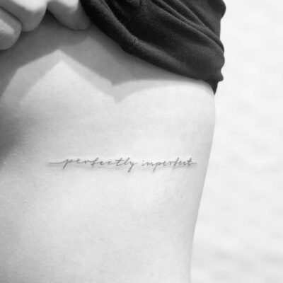 Hình xăm chữ "perfectly imperfect" trên sườn, phong cách tối giản, độ phân giải HD.