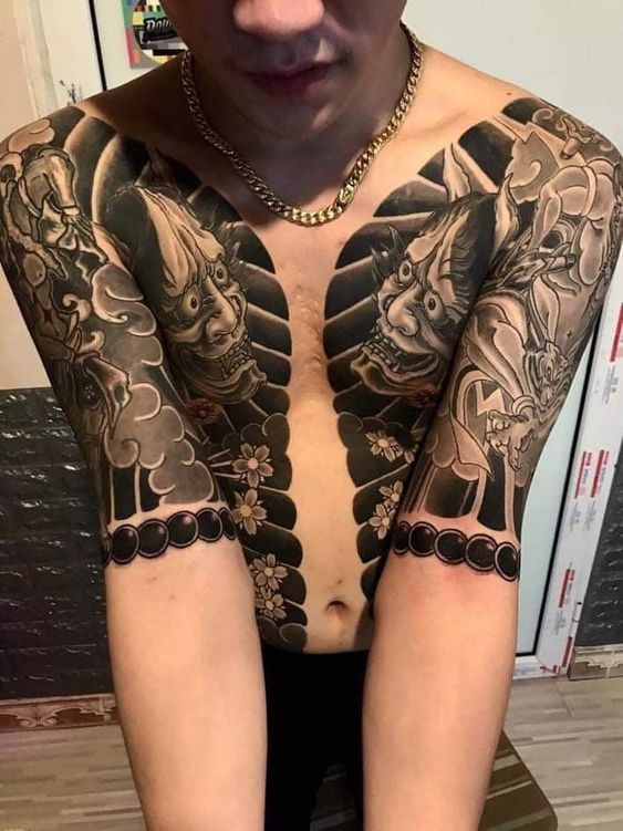 Hình xăm mặt nạ Oni phong cách blackwork trên ngực và cánh tay, chi tiết cao, độ phân giải HD.